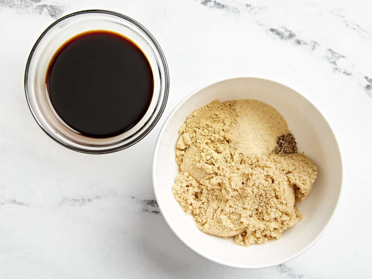 brown sugar and seasonings in a white bowl next to a glass dish of soy sauce.