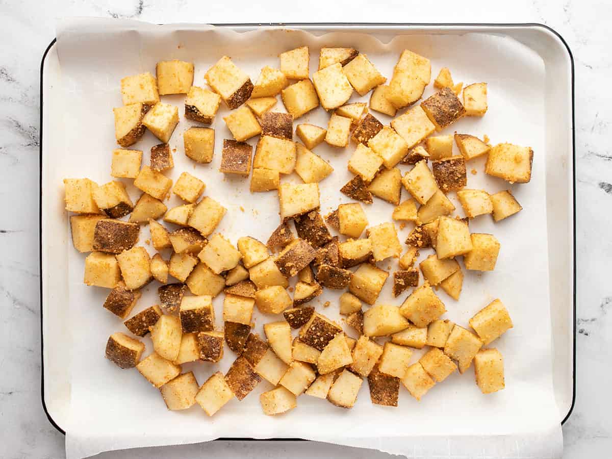 Potatoes on a sheet pan ready to be roasted.