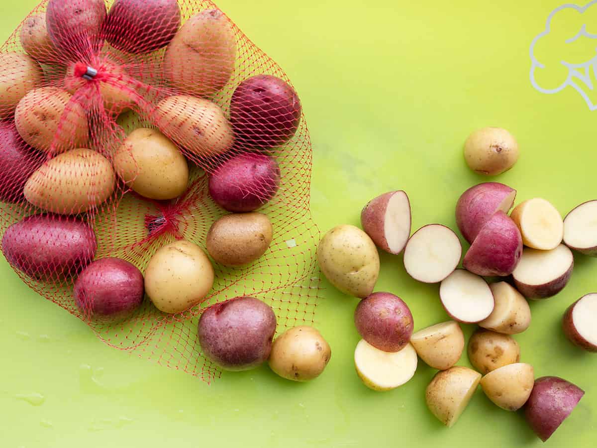 cut baby potatoes on a cutting board