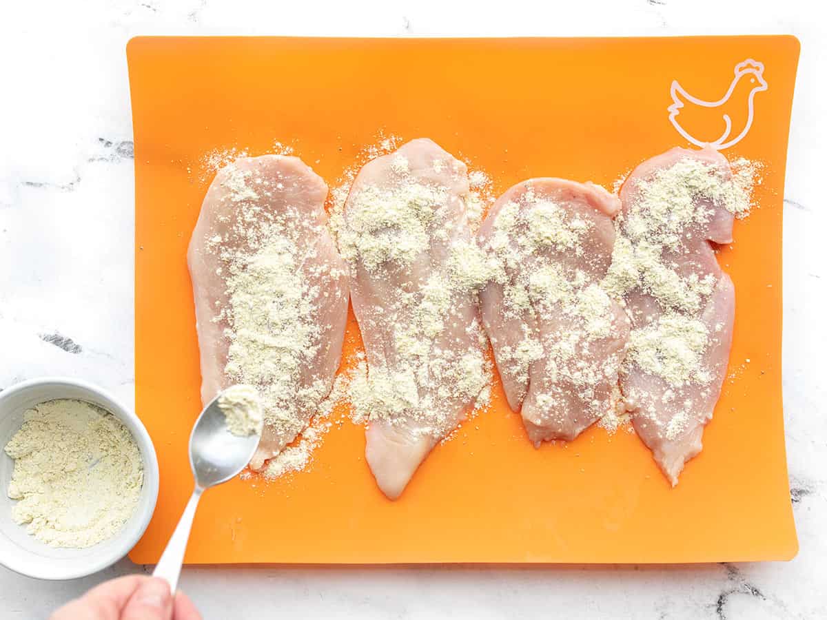 lemon pepper flour being sprinkled over the chicken pieces