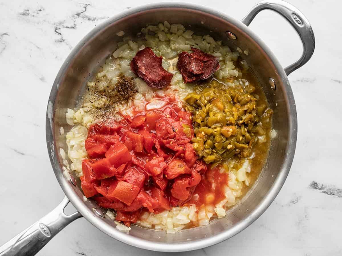 Tomatoes, chiles, and spices added to the skillet.