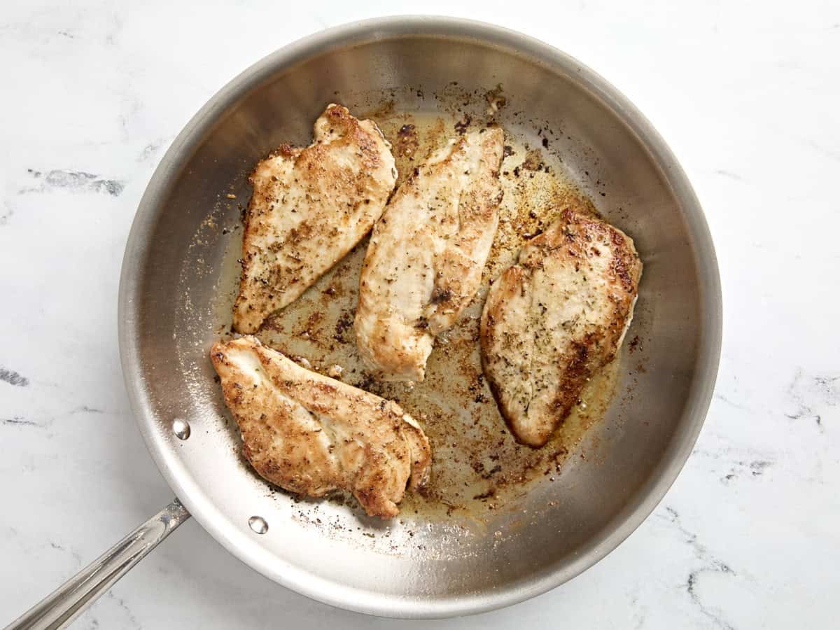 Cooked chicken breasts in a large skillet.