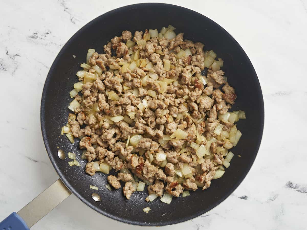 Browned sausage and onion in a nonstick skillet.