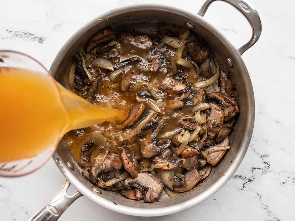 Broth being poured into the skillet.