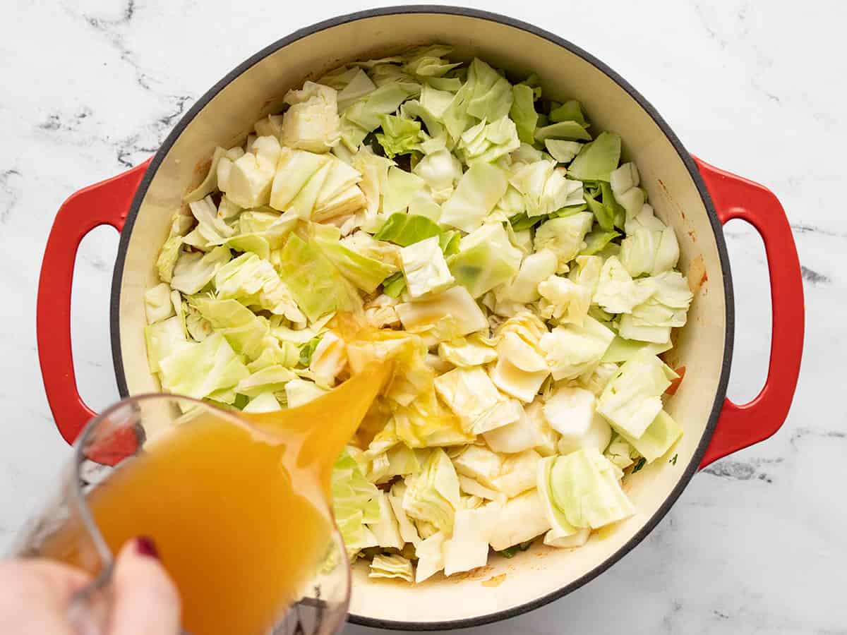 cabbage in soup pot, broth being poured in