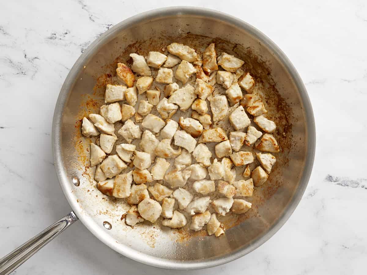 Cooked chicken breast pieces in a skillet.