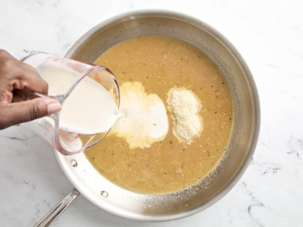 Cream and parmesan cheese added to skillet.