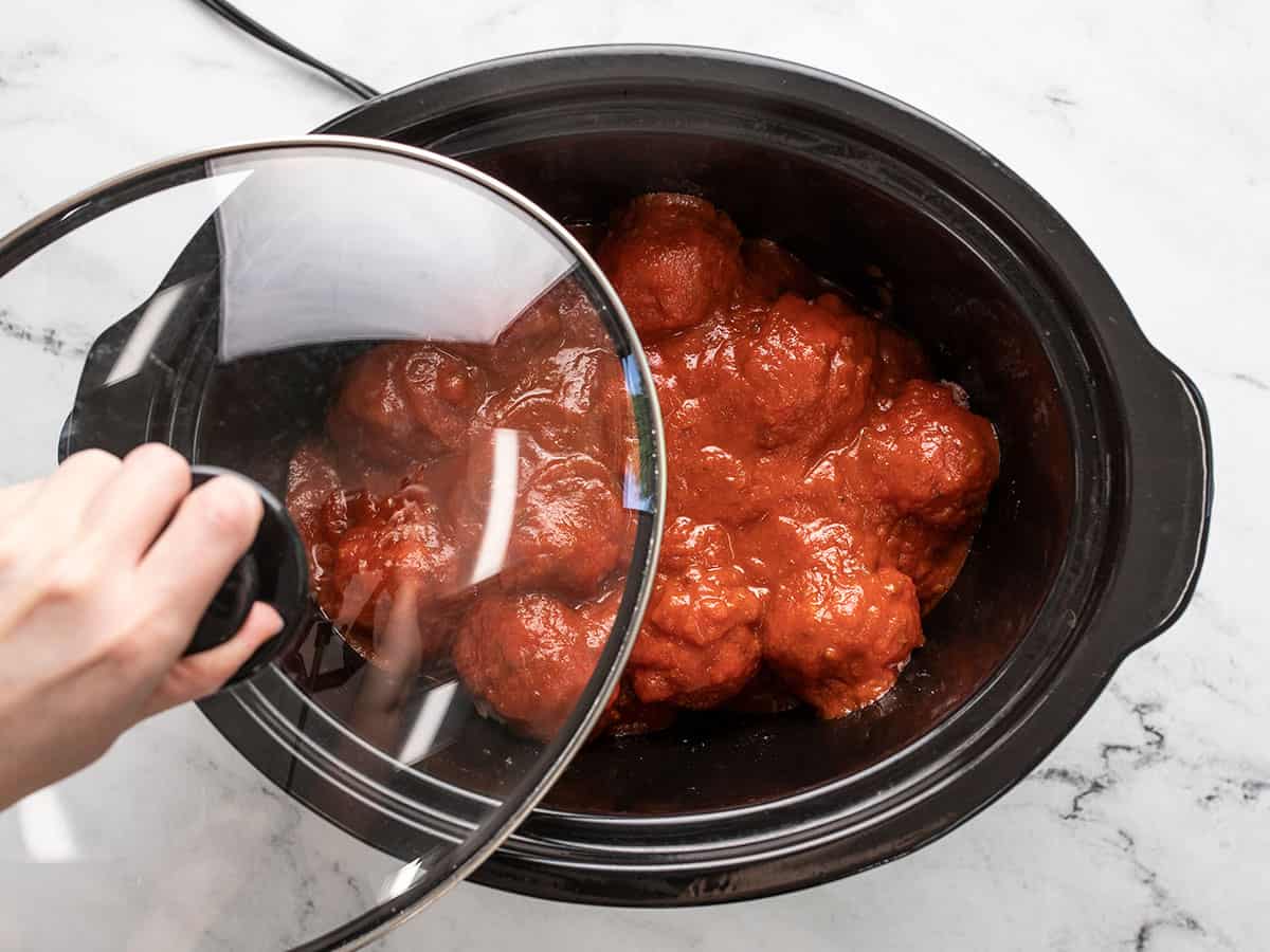 Lid being placed on the slow cooker.