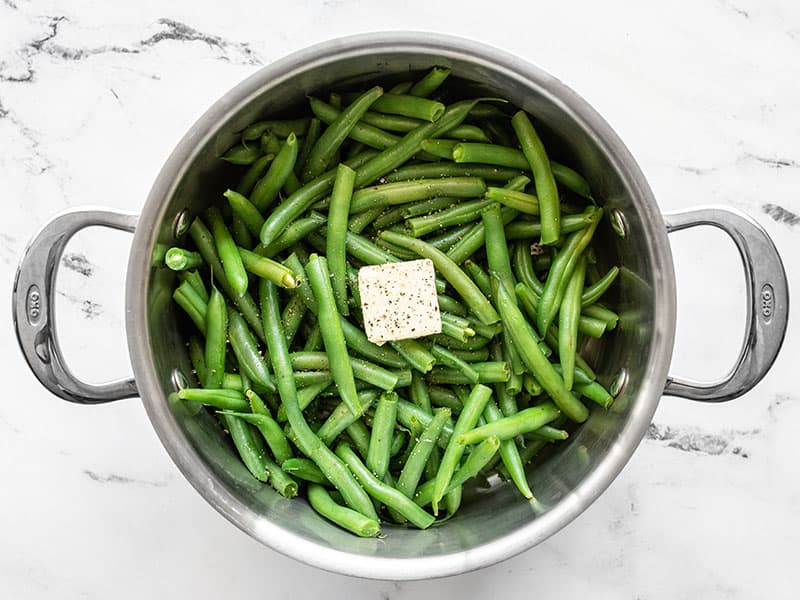 Steamed green beans with butter, salt, and pepper in the pot