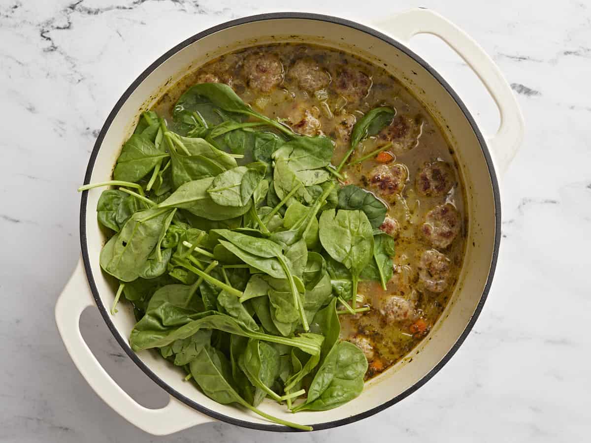 Spinach added to the soup pot. 