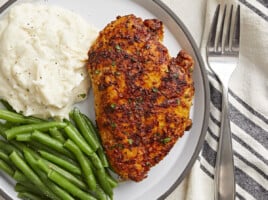 Overhead view of Air Fryer Chicken Breast on a plate with a side of mashed potatoes and green beans.