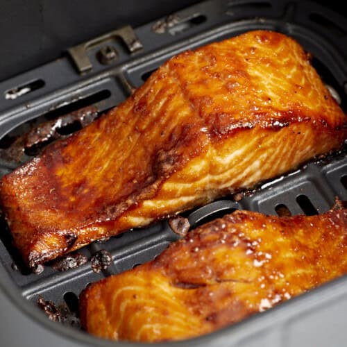 close up of air fryer salmon filets in an air fryer basket.