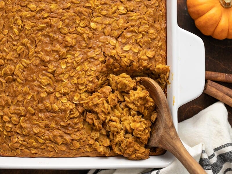 close up of pumpkin pie oatmeal being scooped out of the baking dish.