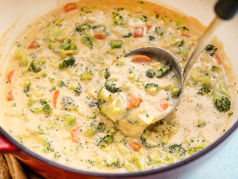 Side view of broccoli cheddar soup in the pot with the ladle