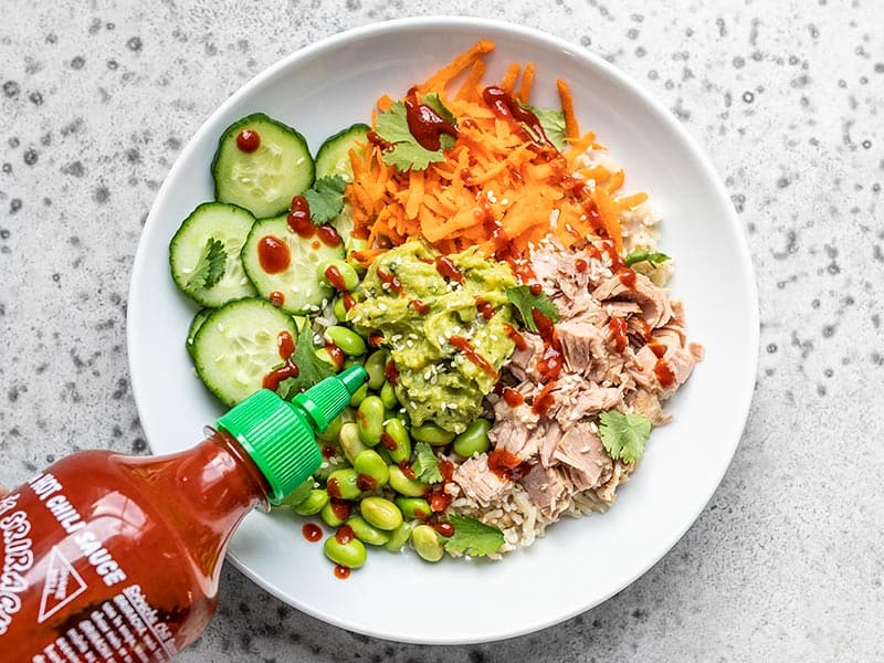 Add tuna, guacamole, sriracha, and sesame seeds to the bowl