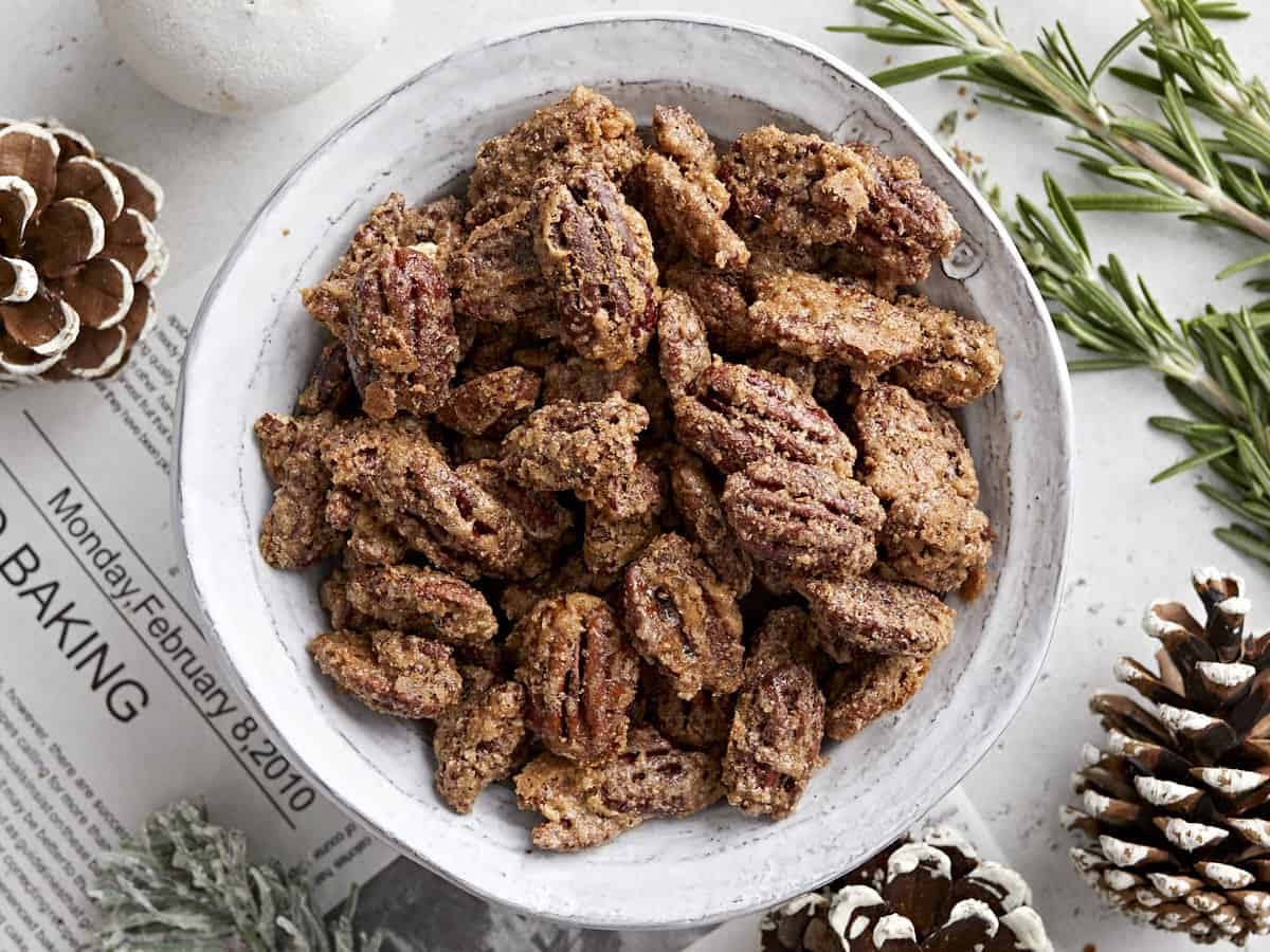 Overhead view of a bowl full of candied pecans. 