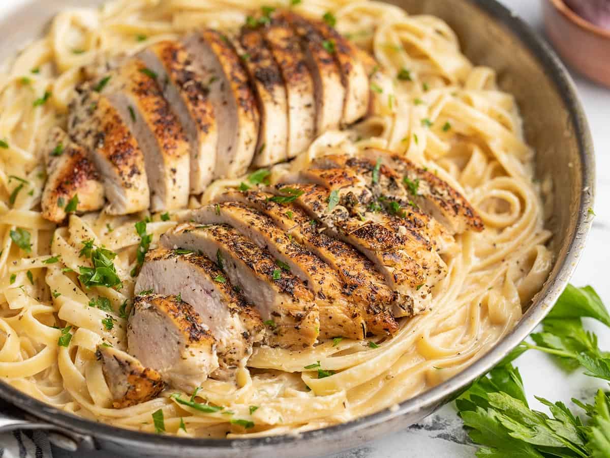 Close up side view of chicken alfredo in the skillet.