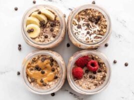 Overhead view of four jars of chocolate overnight oats, each with a different topping