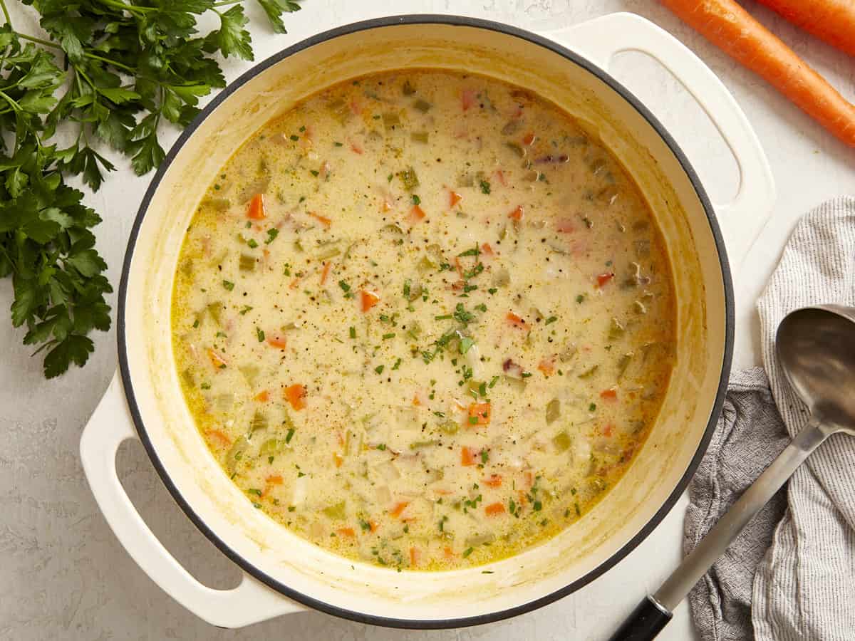 overhead view of ham and potato soup in a white dutch oven.