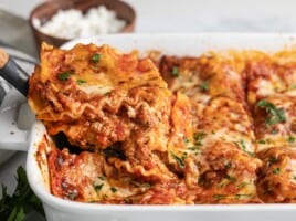 Side view of a slice of lasagna being lifted out of the pan.