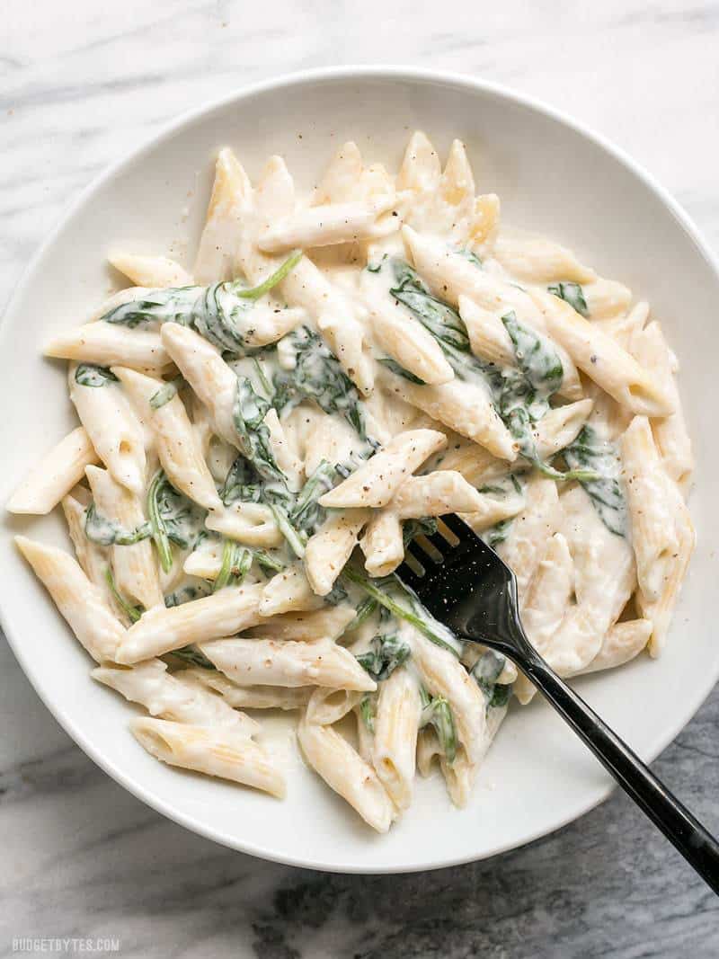 A bowl full of super creamy and delicious "lighter" Spinach Alfredo Pasta