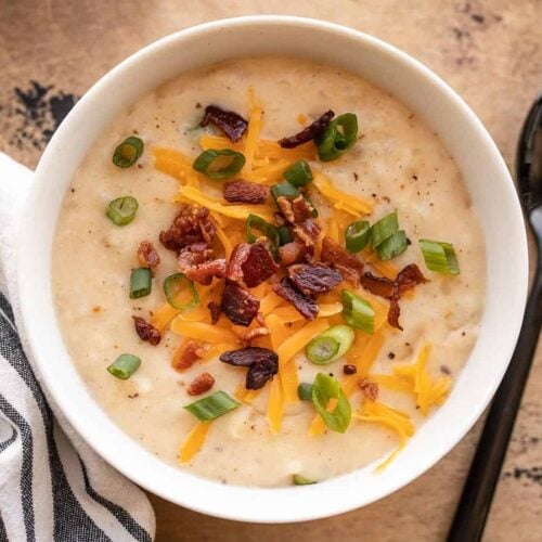 overhead view of a bowl of loaded potato soup with toppings.