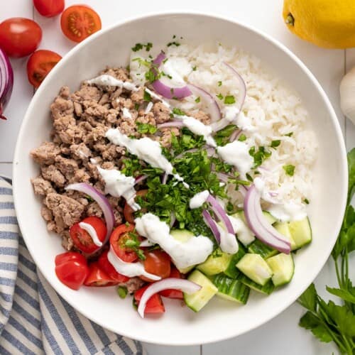 Overhead view of a Mediterranean Turkey Bowl with yogurt sauce drizzled over top.