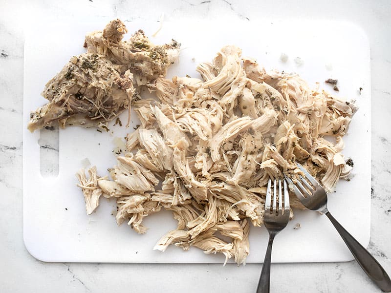 Chicken meat shredded with forks, bones on the side