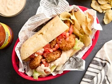 Overhead view of a shrimp po' boy in a basket with potato chips