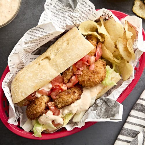 Overhead view of a shrimp po' boy in a basket with potato chips