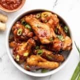 Overhead view of a bowl full of sticky ginger chicken wings