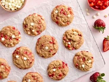 overhead view of 12 strawberry cookies on a parchment-lined wire rack.