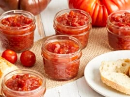 A side view of tomato relish in glass jars.