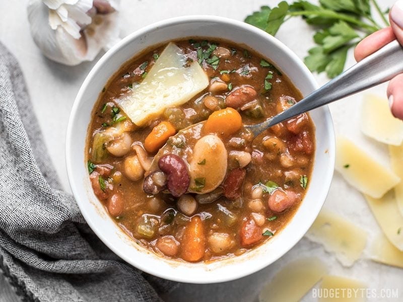 A variety of colors, fresh vegetables, and vibrant herbs and spices make this Vegetarian 15 Bean Soup flavorful, filling, AND incredibly good for you. BudgetBytes.com